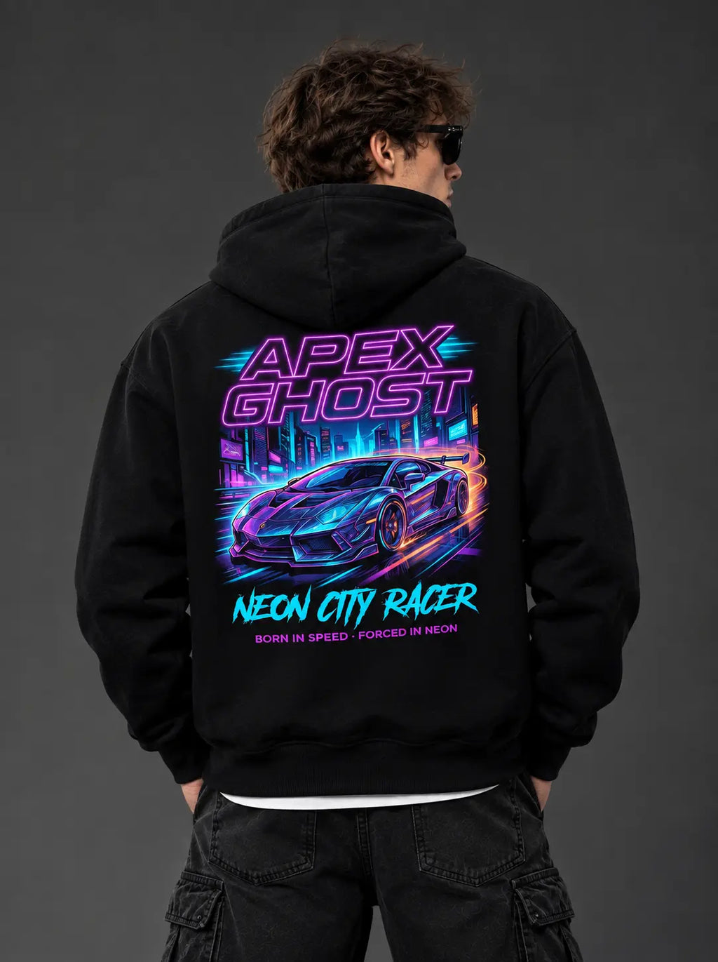 Man wearing black hoodie showing full back graphic with neon supercar and BORN IN SPEED · FORCED IN NEON text